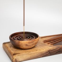 a wooden bowl with sticks sticking out of it