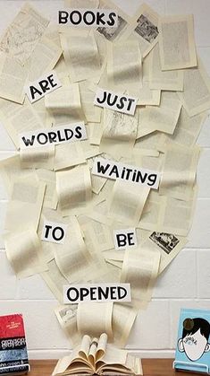 an open book sitting on top of a wooden table next to books with words written on them