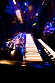 an electronic keyboard sitting on top of a table in front of a microphone and sound board