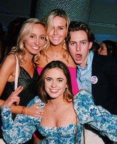 three women and one man posing for the camera