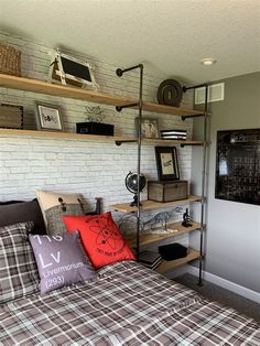 a bed room with a neatly made bed and some shelves on the wall above it