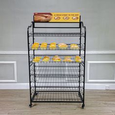 a metal rack with pastries on it in front of a gray wall and wooden floor