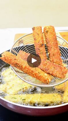 fried food being cooked in a frying pan on top of a stove burner