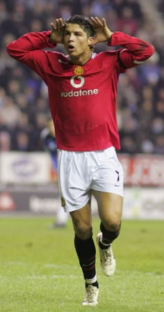 a soccer player is running on the field with his hands behind his head as he covers his eyes