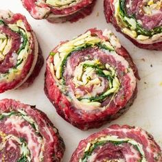 raw meat rolls with spinach and cheese on top