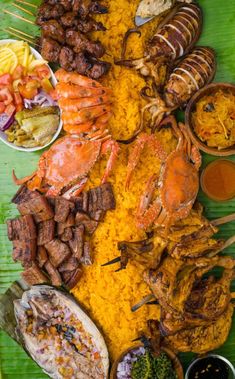 an assortment of food is laid out on a banana leaf with sauces and condiments