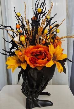 a vase filled with lots of flowers on top of a white table next to a window