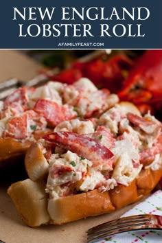 lobster salad in a lobster roll on top of a plate with a fork and knife