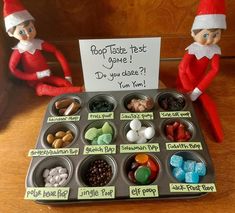 two elfs sitting next to each other near a tray with candy and marshmallows