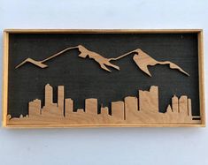 a wooden cutout of two birds flying in the sky over a cityscape