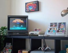 a computer monitor sitting on top of a desk next to a keyboard and game controller