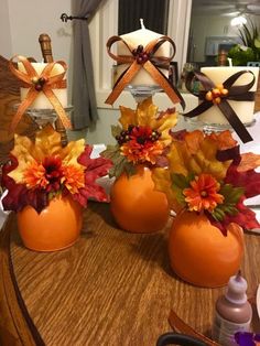 three vases filled with flowers on top of a table