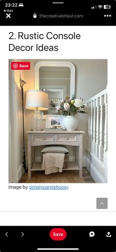 a white table with a mirror and lamp on top of it next to a stair case