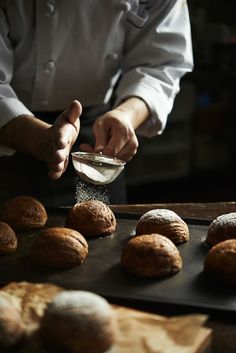 a chef sprinkling sugar on some bread