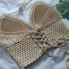 a pair of crocheted shoes sitting on top of a bed