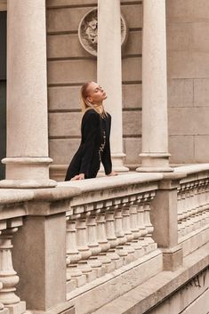 a woman standing on the side of a building looking up