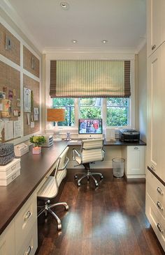 an office with wood floors and white cabinets