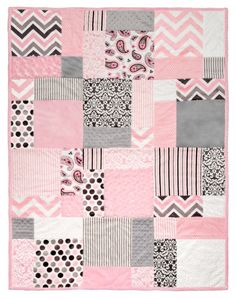 a pink and gray patchwork blanket with black, white, and grey designs