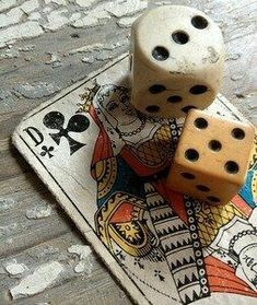 two dices sitting on top of a playing card