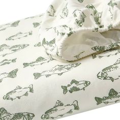 a white sheet with green fish on it