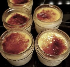 four jars filled with food sitting on top of a stove