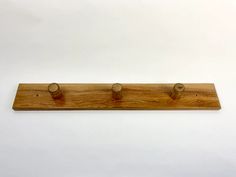 a wooden coat rack with three knobs on it