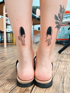 a woman's legs with two tattoos on them