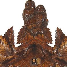 an ornate wooden cuckoo clock with two owls on it