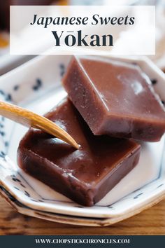 two pieces of chocolate on a plate with chopsticks in it and the words japanese sweets yokan