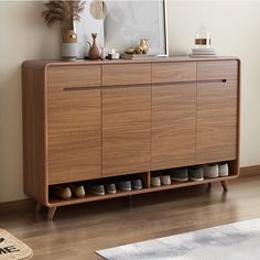 a wooden cabinet with several pairs of shoes on it and a rug in front of it