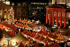 an aerial view of the christmas market at night with lights on trees and buildings in the background