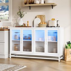 a white cabinet with glass doors in a kitchen next to a counter top and cabinets