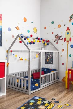 a child's bedroom with space themed wallpaper and wooden flooring, including a toy house bed