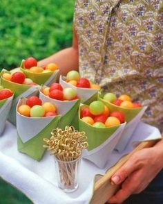 a person holding a tray filled with apples