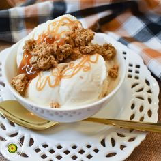 an ice cream sundae with caramel sauce and crumbled topping on top