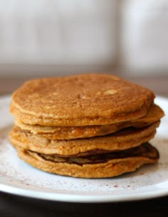 a stack of pancakes sitting on top of a white plate