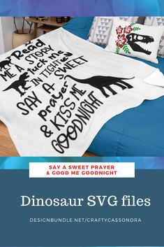 a bed covered in a white dinosaur t - shirt with black writing on the side