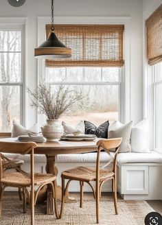 a dining room table and chairs in front of a window