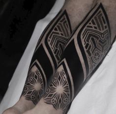 a man's arm with black and white tattoos on it