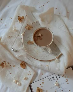 a cup of coffee sitting on top of a saucer next to an open book