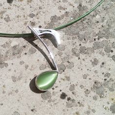 a pair of silver spoons sitting on top of a cement floor next to a wire