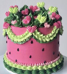 a pink and green cake with flowers on top