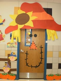 a door decorated to look like a scarecrow with a sunflower on its head