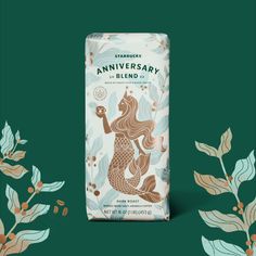 a box of starbucks's anniversary blend on a green background with leaves and flowers