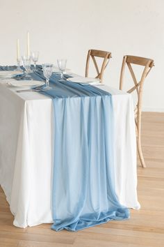 the table is set with white and blue linens