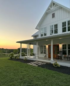 a large white house sitting on top of a lush green field