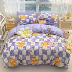 a bed with purple and white checkered bedspread, teddy bear stuffed animal on the pillow