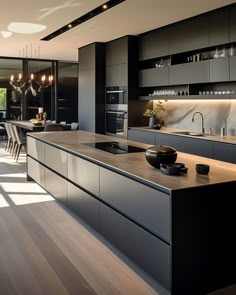 a modern kitchen with black cabinets and wood flooring