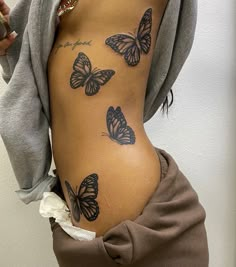 a woman's stomach with butterflies on it and the bottom part of her body