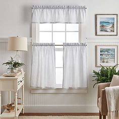 a living room with white walls and curtains